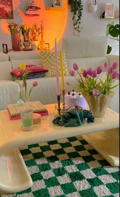 a living room filled with furniture and flowers on top of a table in front of a white couch