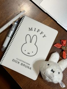 a notepad with a bunny on it next to a pen and a stuffed animal