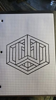 a notebook with a drawing of a cube in the middle on top of graph paper