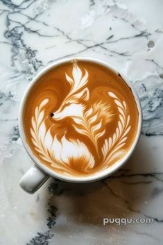 a cup of coffee with white designs on it