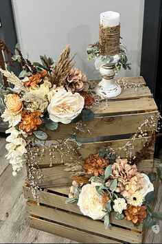 two wooden boxes with flowers and candles on them