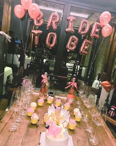 a wooden table topped with lots of cake and cupcakes