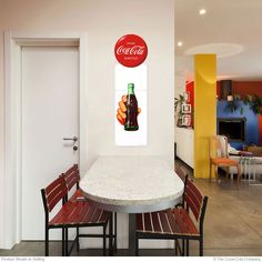 a table and chairs in a room with a coca - cola sign on the wall