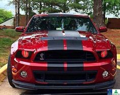 the front end of a red and black mustang