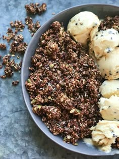 a bowl filled with ice cream and granola on top of a blue tablecloth