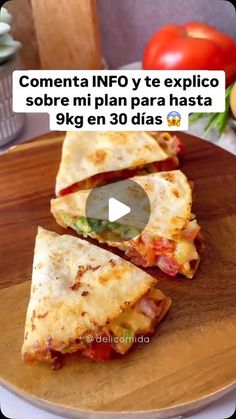 two quesadillas cut in half on a wooden plate with tomatoes and lettuce