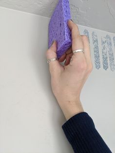 a person is holding a purple object in their hand while they are working on it