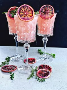 three wine glasses filled with blood oranges and garnish