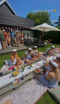 a group of women sitting on top of a picnic table in front of a house