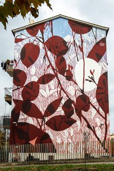 a large mural on the side of a building with trees and leaves painted on it