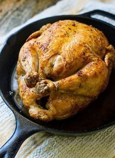 a cooked chicken in a cast iron skillet