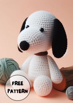 a crocheted dog sitting next to two balls of yarn