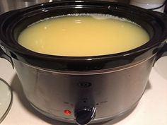 a crock pot filled with soup sitting on top of a stove