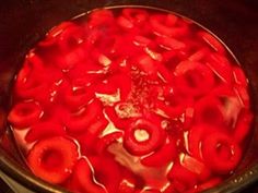 a pan filled with red liquid sitting on top of a stove