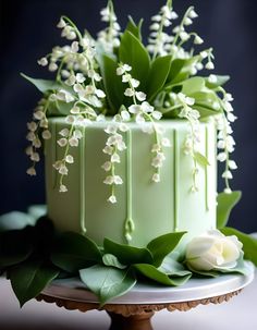 a green cake with white flowers on top