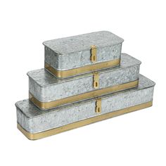 three metal boxes stacked on top of each other with gold trimmings and handles