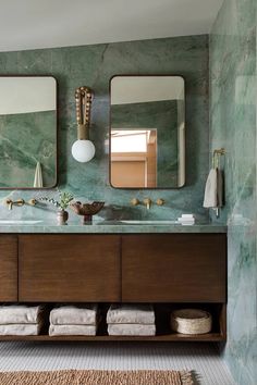 a bathroom with marble walls and two mirrors