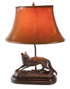 a lamp that is on top of a wooden base with a deer figurine underneath it