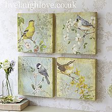 three birds are hanging on the wall next to a vase with flowers and a flower pot