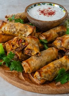 some food is on a wooden platter with a bowl of ranch dressing in the background