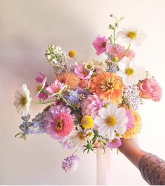 a person holding a bouquet of flowers in their hand