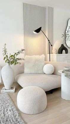 a living room filled with white furniture and decor