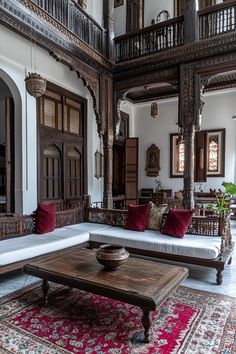 a living room filled with furniture and lots of woodwork on the walls next to a red rug