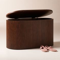 a pair of pink shoes sitting on top of a wooden box next to a shoe rack