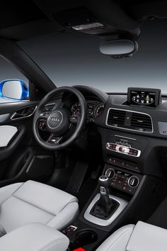 the interior of an audi car with white leather seats and dashboard controls, including steering wheel