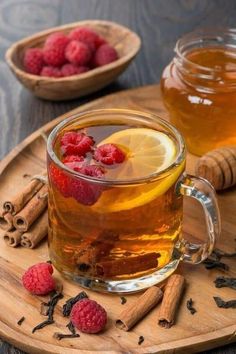 a glass cup filled with tea and raspberries