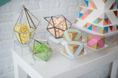 several different shapes and sizes of candies on a white table next to a brick wall