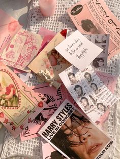 many pink and white papers are scattered on the tablecloth, with one person's face in the center