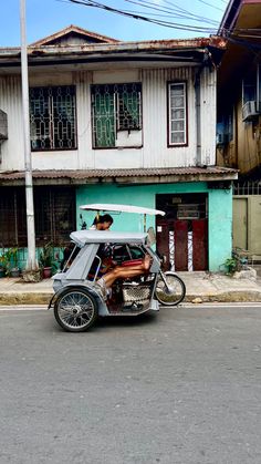 an old motorcycle with a side car parked in front of a building on the street