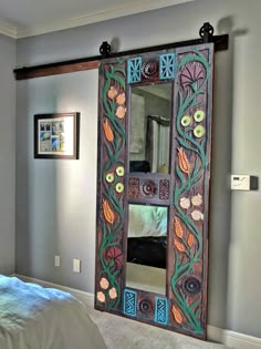 an ornately decorated mirror is in the middle of a room with a bed and pictures on the wall