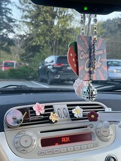 a car dashboard with an air freshener hanging from it's dash board and flowers