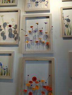 four framed pictures with flowers in them on the wall