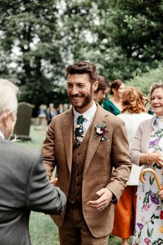 a man in a suit and tie standing next to other people