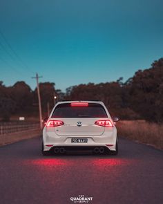 the back end of a white car with red lights