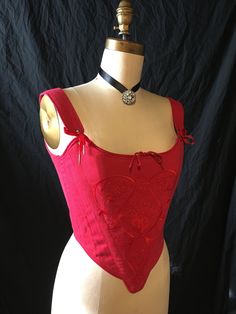 "History is beautiful with this embroidered red linen 18th century stays. This c.1770's corset achieves the conical shape required during the 18th century, using 1/2\" steel bones and horizontal boning across the bust. There is little shaping under the bust, and the bust is pushed up to a higher position. This style has shoulder straps attached with adjustable front ribbon lacing. It is made in a cranberry red linen with matching red ribbon laces at the back. The stomacher front of the corset is Red Overbust Bodice With Boning, Red Boned Overbust Bodice, Red Overbust Boned Bodice, Red Boned Bodice Corset For Costume, Red Fitted Corset With Boning, Red Corset With Boning, Red Fitted Bodice Corset With Boning, Fitted Red Bodice With Corset Back, Red Corset With Fitted Bodice And Corset Back