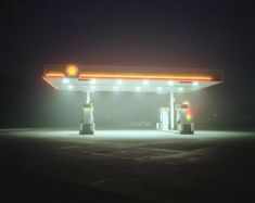 an empty gas station at night with the lights on