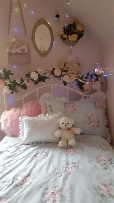 a white teddy bear sitting on top of a bed in a room with pink walls