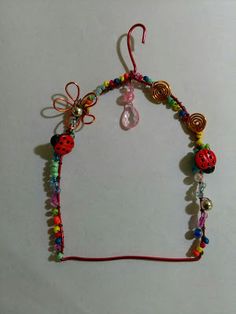 an image of a necklace with beads and bows on the front, from all about the garden