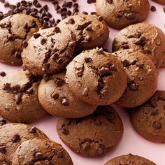 chocolate chip cookies and chocolate chips on a pink surface