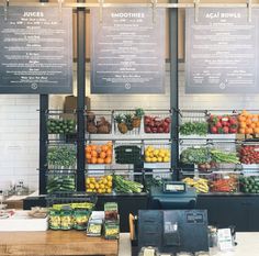 the produce section of a grocery store with signs above it that read, juice and smoothies