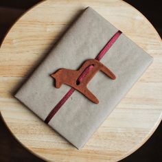 a wrapped present sitting on top of a wooden table next to a brown dog ornament