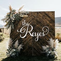 a wooden sign that says the reves on it with flowers and feathers around it