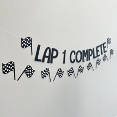 some black and white flags hanging on the wall next to a sign that says lap 1 complete