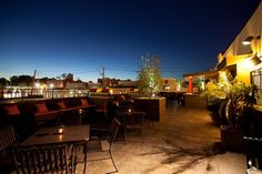 an outdoor patio with tables and chairs at night