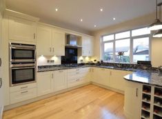 a kitchen with white cabinets and black counter tops