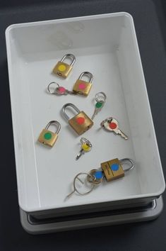 several padlocks and keys on a white tray